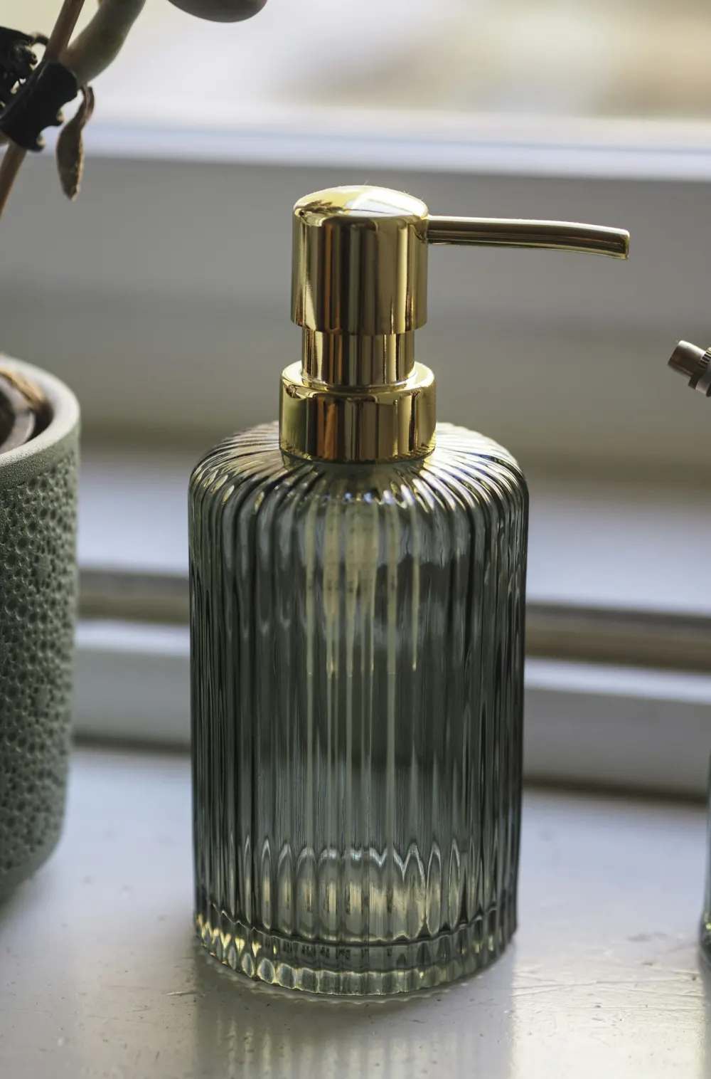 Ribbed glass soap dispenser with a brass pump