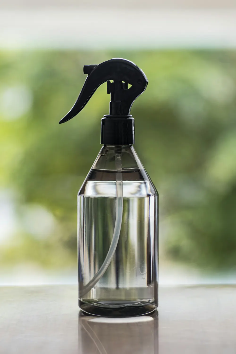 Clear glass spray bottle with a black trigger