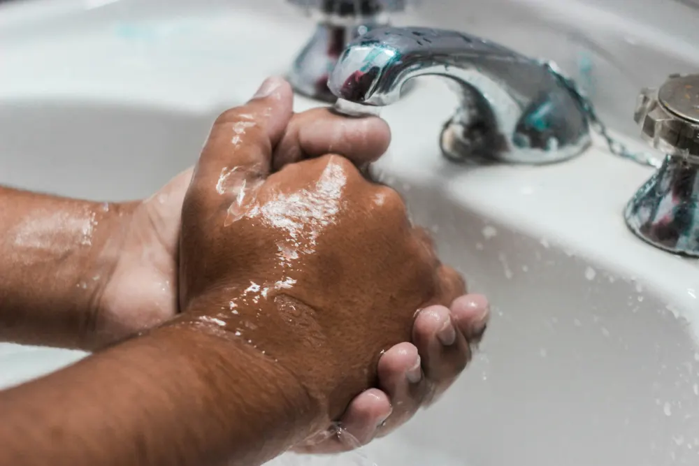 Washing hands under a running tap