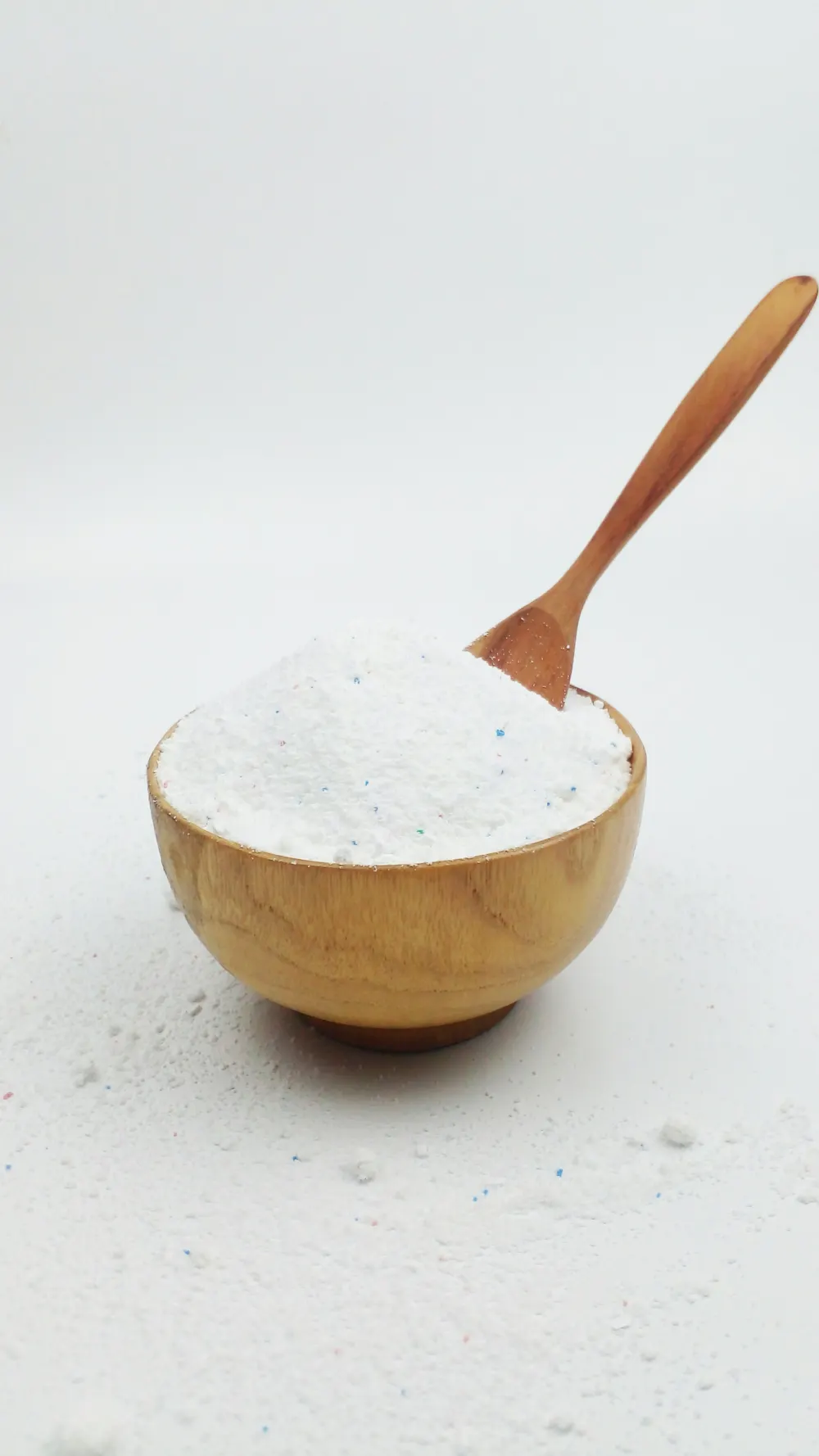 Laundry powder in a wooden bowl with a wooden scoop